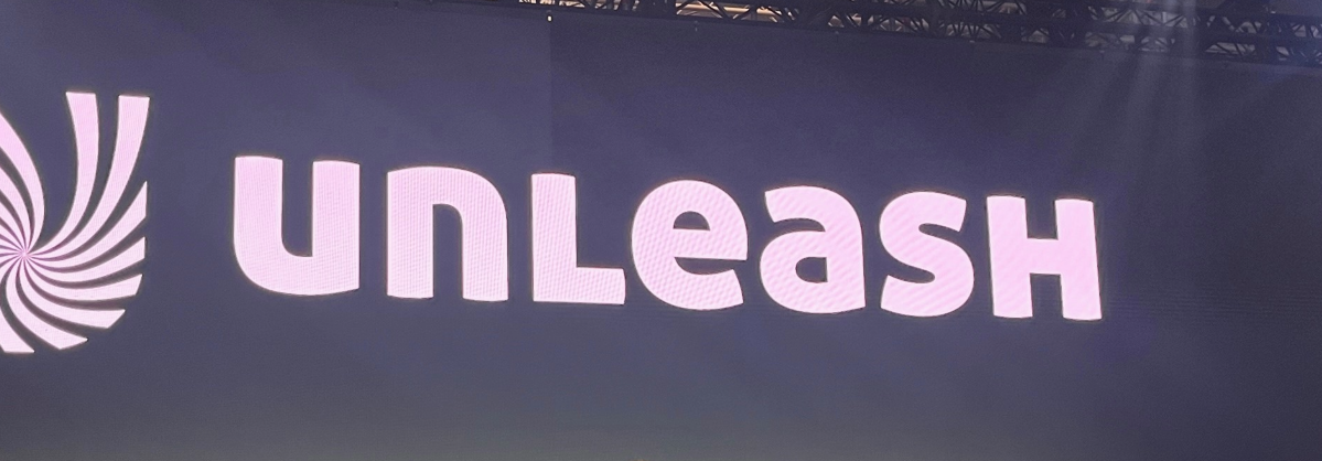 Texten "Unleash" med en snurrande spiral-logotyp till vänster, på en mörk bakgrund.
