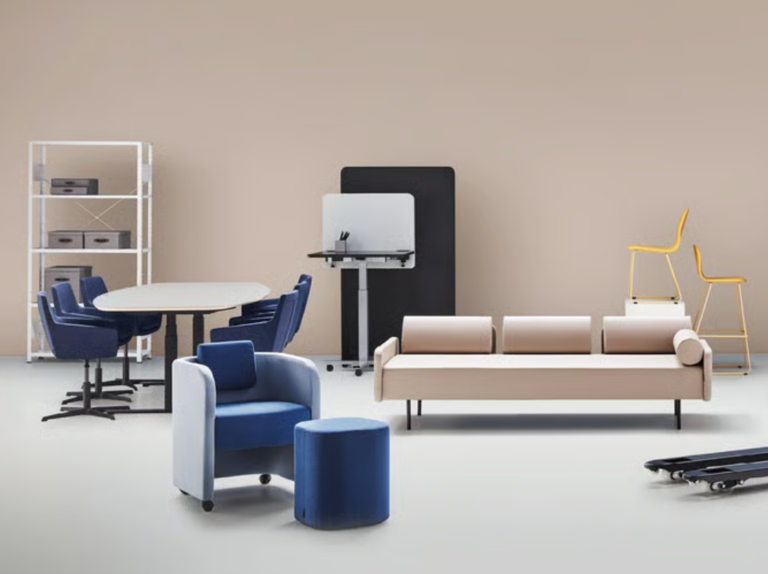 Olika moderna kontorsmöbler inklusive soffa, bord, stolar, hylla och arbetsstation mot beige vägg.